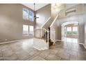 Welcoming entryway boasts tile floors, a staircase, soaring ceilings, and natural light at 4449 E Rancho Caliente Dr, Cave Creek, AZ 85331