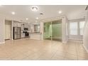 Open-concept living room with tile flooring, sliding glass doors to the patio, and a breakfast bar to the kitchen at 4853 S Charger --, Mesa, AZ 85212
