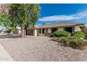 Well-kept single-story home boasting desert landscaping, a tile roof, and a cozy front porch at 560 E San Pedro Ave, Gilbert, AZ 85234