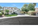Inviting two-story home with a well-manicured lawn, lush green landscaping, and a spacious three-car garage at 5726 W Park View Ln, Glendale, AZ 85310