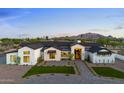 Stunning modern farmhouse with stone accents, black trim, and lush landscaping against a mountain backdrop at 6147 E Desert Cove Ave, Scottsdale, AZ 85254