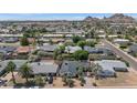An aerial view showcases the neighborhood with mountain views in the distance on a sunny day at 6207 E Rose Circle Dr, Scottsdale, AZ 85251