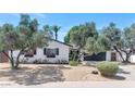 Lovely single-story home with an attached garage, flower boxes, and mature landscaping under a blue sky at 6207 E Rose Circle Dr, Scottsdale, AZ 85251