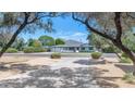 A ranch-style home sits facing the street, framed by trees and a manicured lawn on a sunny day at 6207 E Rose Circle Dr, Scottsdale, AZ 85251