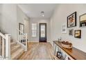 Welcoming entryway featuring wood flooring, stairs, and a decorative console table at 6503 E Bluefield Ave, Phoenix, AZ 85054