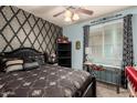 Cozy bedroom featuring elegant black furniture, decorative wallpaper, and a light blue accent wall at 7015 W Melody Dr, Laveen, AZ 85339