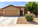 Charming single-Gathering home featuring a two-car garage, desert landscaping, and a covered entryway at 7015 W Melody Dr, Laveen, AZ 85339