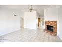 Open-concept living room with tile flooring, brick fireplace, and seamless flow into the kitchen at 722 W Topeka Dr, Phoenix, AZ 85027