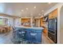 Kitchen with breakfast bar seating, wood cabinets, stainless appliances, and an adjacent dining area at 8606 E Arroyo Seco Rd, Scottsdale, AZ 85266