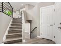 Inviting entryway with hardwood floors, staircase with black metal railing, and a neutral color palette at 8829 W Sheridan St, Phoenix, AZ 85037