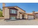 Beige two-story home with a well-maintained lawn and inviting entrance at 8829 W Sheridan St, Phoenix, AZ 85037