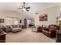 Spacious living room featuring vaulted ceilings and stylish furnishings, with a ceiling fan at 11543 W Sandsnake Ct, Surprise, AZ 85378