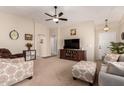 Bright and airy living room featuring a ceiling fan, comfortable furnishings, and neutral tones at 11543 W Sandsnake Ct, Surprise, AZ 85378