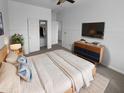 A cozy bedroom is showcased with soft lighting, a comfortable bed, and a modern entertainment setup at 13335 W Marlette Ct, Litchfield Park, AZ 85340