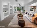 Bright living room featuring recessed lighting, built-in shelving, neutral furniture, and backyard views at 13335 W Marlette Ct, Litchfield Park, AZ 85340