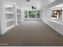 A spacious room is showcased with large windows overlooking a pool, complemented by built-in shelving at 13335 W Marlette Ct, Litchfield Park, AZ 85340