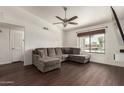 Living room with dark wood floors, large window, and comfortable gray couch at 1402 E Guadalupe Rd # 234, Tempe, AZ 85283