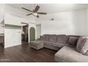 Open concept living room featuring a comfortable gray couch and dark wood floors at 1402 E Guadalupe Rd # 234, Tempe, AZ 85283