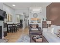Open-concept living space featuring stylish furniture, wood flooring, and easy access to the dining area at 14203 N 19Th Ave # 2036, Phoenix, AZ 85023