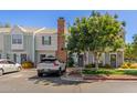 Inviting townhouse featuring a brick chimney, front yard landscaping, and off-street parking at 1600 N Saba St # 143, Chandler, AZ 85225