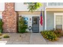 Inviting townhouse entrance with brick details, landscaping, and an American flag displayed at 1600 N Saba St # 143, Chandler, AZ 85225