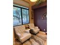 Comfortable sitting area featuring tufted chairs, a decorative rug, and a bright window with natural light at 16820 E La Montana Dr # 105, Fountain Hills, AZ 85268