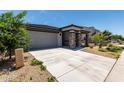View of the property featuring a driveway, attached garage and desert landscaping at 18021 W Avenida Del Sol --, Surprise, AZ 85387