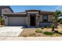 Charming single-level home featuring a stone-accented entrance, well-maintained landscaping, and a welcoming facade at 18021 W Avenida Del Sol --, Surprise, AZ 85387