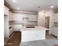 Bright kitchen featuring an expansive island, and white cabinets offering ample storage and counter space at 18165 W Larkspur Dr, Goodyear, AZ 85338