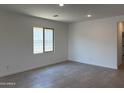 Bright, open living room with tile flooring, recessed lighting, and a large window offering plenty of natural light at 18165 W Larkspur Dr, Goodyear, AZ 85338