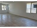 Bright, open living room with tile flooring, recessed lighting, and large windows offering plenty of natural light at 18165 W Larkspur Dr, Goodyear, AZ 85338