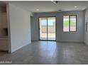 Bright, open living room featuring tile flooring, recessed lighting, and sliding glass door access to the backyard at 18165 W Larkspur Dr, Goodyear, AZ 85338