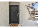 Inviting condo front door with secure lock system, a welcome home mat, and convenient stair access at 2025 E Campbell Ave # 107, Phoenix, AZ 85016