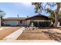 Inviting single-Gathering home featuring a decorative fountain, mature landscaping, and a two-car garage at 2114 N 69Th Pl, Scottsdale, AZ 85257