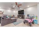 Spacious living room with tile flooring, ceiling fans, and a large sectional sofa at 2114 N 69Th Pl, Scottsdale, AZ 85257