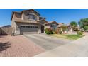 Charming two-story home with attached garage, rock landscaping, and grass at 2152 W Sunshine Butte Dr, San Tan Valley, AZ 85144