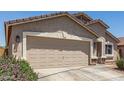 Two car garage door with stone accents, desert landscaping, and concrete driveway at 22534 W Pima St, Buckeye, AZ 85326