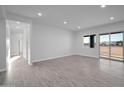 Spacious living room with sleek flooring, recessed lighting, and sliding glass doors to the outside at 22548 W Huntington Dr, Buckeye, AZ 85326