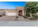 Charming single-story home with a brick-paved driveway and stone-accented entryway at 24953 N 172Nd Dr, Surprise, AZ 85387