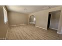 Spacious living area with wood-look flooring, arched doorway, and neutral color palette at 2548 E Encanto St, Mesa, AZ 85213