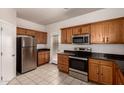 Bright kitchen featuring stainless steel appliances, granite countertops, and classic wood cabinetry at 2640 N 73Rd Gln, Phoenix, AZ 85035