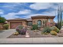 Charming single-story home boasts a well-manicured desert landscape with colorful flowering bushes at 3522 W Rushmore Dr, Anthem, AZ 85086