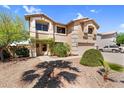 Charming two-story home with an attached garage, complemented by desert landscaping and lush green trees at 3786 S Chaparral Rd, Apache Junction, AZ 85119