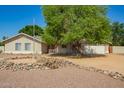 Charming single-story home featuring a covered porch, gravel yard, and mature tree at 3964 S Turquoise Dr, Buckeye, AZ 85326