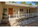 Covered front porch with decorative wood door, white railing, and flower accents at 3964 S Turquoise Dr, Buckeye, AZ 85326