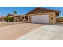 Wide driveway leading to a two-car garage, enhanced by desert landscaping and decorative touches at 4145 W Hayward Ave, Phoenix, AZ 85051