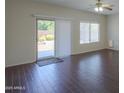 Living room featuring wood floors, a ceiling fan and sliding glass door to backyard at 44092 W Stonecreek Rd, Maricopa, AZ 85139