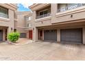Townhome showing gray garage door and decorative balcony railings at 4455 E Paradise Village S Pkwy # 1057, Phoenix, AZ 85032