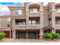 Inviting townhome exterior with a two-car garage and balcony railings at 4455 E Paradise Village S Pkwy # 1057, Phoenix, AZ 85032