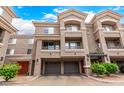 Townhome with two-car garage, decorative balcony railings, and lush landscaping at 4455 E Paradise Village S Pkwy # 1057, Phoenix, AZ 85032
